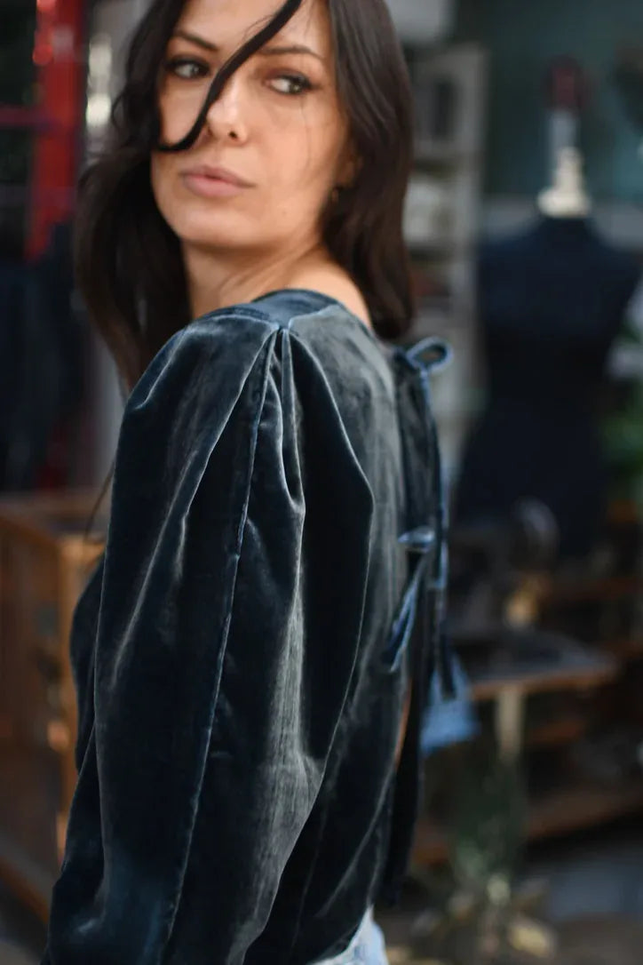 
                  
                    Blusa de terciopelo de seda azul con mangas con volumen en el hombro, vista de tres cuartos.
                  
                