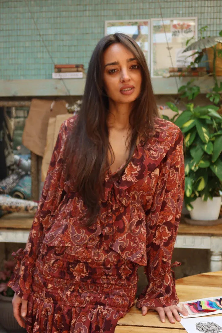 Blusa de gasa con estampado paisley terracota, escote en V con volante y mangas amplias, vista frontal.