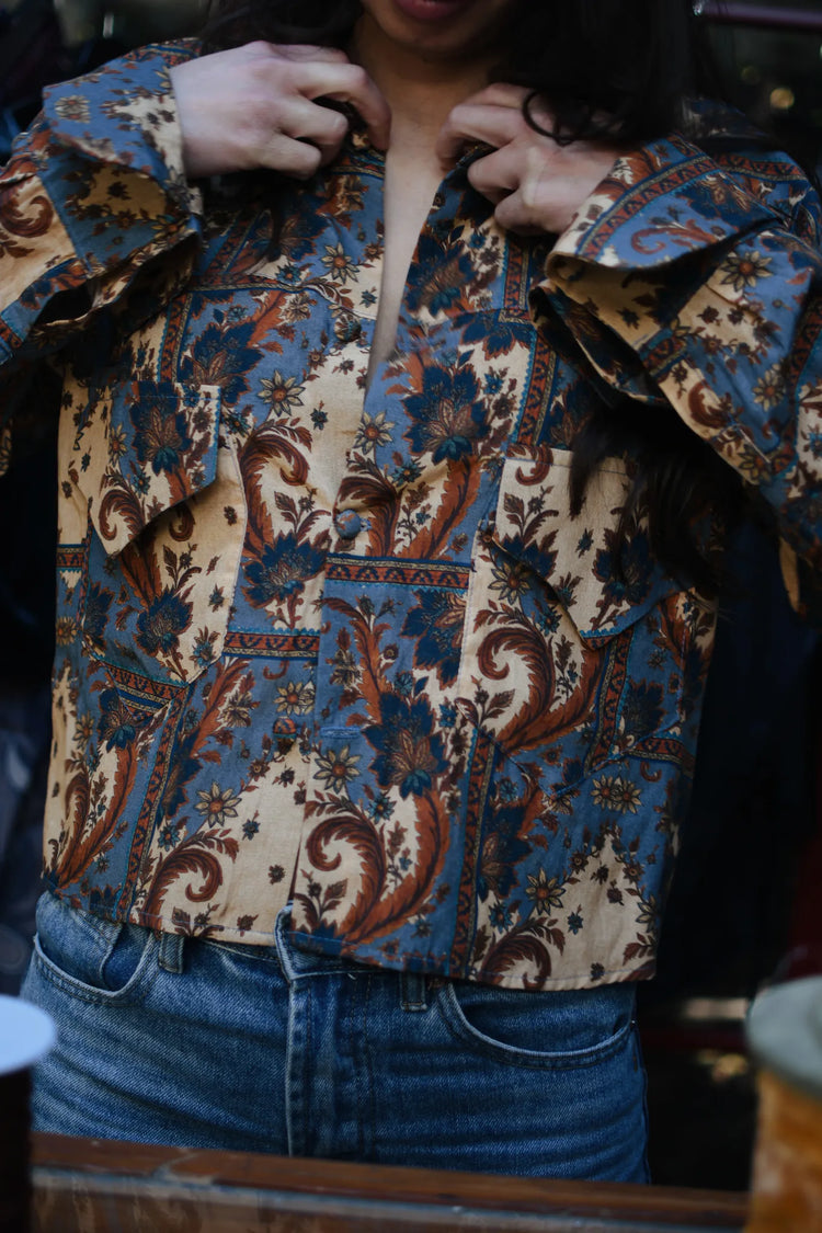 
                  
                    Blusa de corte vaquero con estampado patchwork azul y terracota, detalle del puño y el canesú.
                  
                