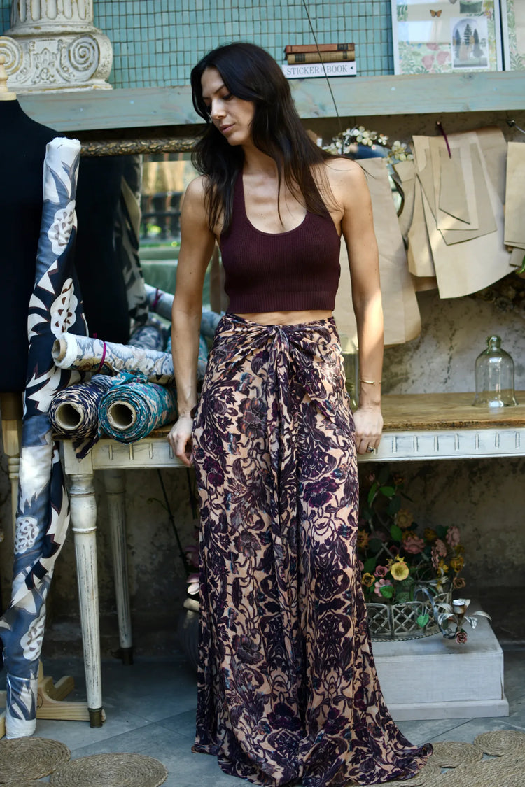 Pantalón palazzo de gasa con estampado floral burdeo sobre fondo damasco, vista frontal de cuerpo completo.